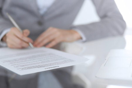 Close-up of female hands with pen over document,  business concept. Lawyer or business woman at work...