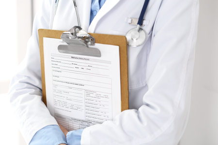 Female doctor using medical form on clipboard closeup.  Physicianat work in hospital or clinic....