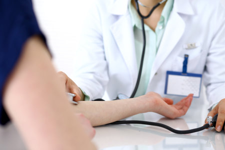 Doctor woman checking blood pressure of female patient, close-up. Cardiology in medicine  and health care conceptの写真素材