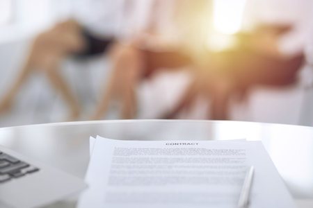 Contract with a pen and blurred business people on the background, close-up. Female candidates waiting for interview at queueの写真素材