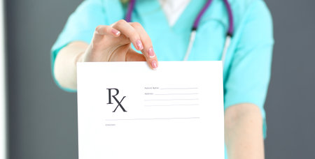 Female doctor holds prescription form while standing straight in hospital closeup. Healthcare, insurance and excellent service in medicine concept.の写真素材