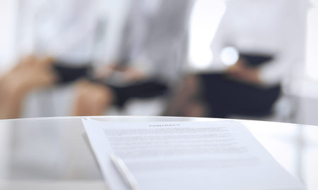 Contract with a pen and blurred business people on the background, close-up. Female candidates...