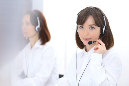 Call center. Group of operators at work. Focus on young brunette woman. Business  conceptの写真素材