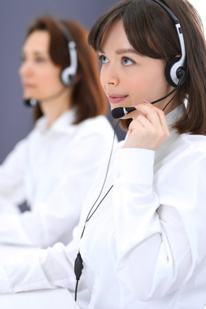 Call center. Group of operators at work. Focus on young brunette woman. Business  conceptの写真素材