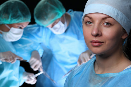 Closeup of surgeons performing operation. Focus on female nurse. Medicine, surgery and emergency help conceptsの写真素材
