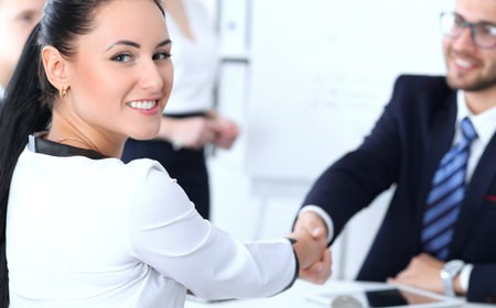 Business handshake at meeting or negotiation in the office. Two businesspeople partners are satisfied because signing contract or financial papersの写真素材