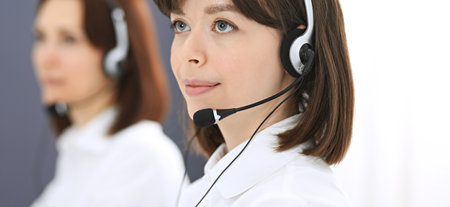 Call center. Group of operators at work. Focus on young brunette woman. Business  conceptの写真素材