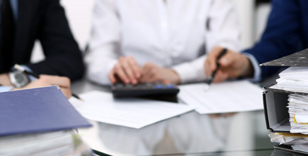 Binders with papers are waiting to be processed with bookkeeper. Internal Revenue Service inspector working place. View from aboveの写真素材