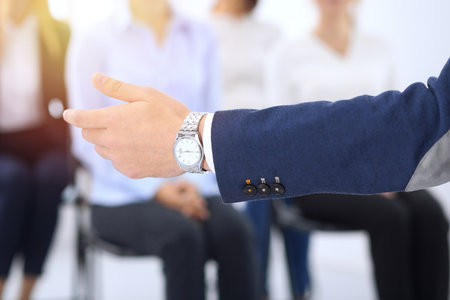 Business man making presentation to group of people. Speaker delivering a seminar to his colleagues or business training. Teamwork and coaching conceptの写真素材