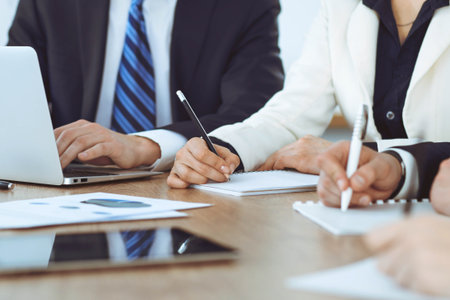 Group of business people or lawyers  work together at meeting in office, hands using tablet and making notes close-up. Negotiation and communication conceptの写真素材