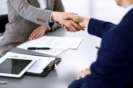 Business people shaking hands, finishing up a meeting. Papers signing, agreement and lawyer consulting conceptの写真素材