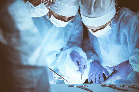 Group of surgeons at work while operating at hospital. Health care and veterinary conceptの写真素材