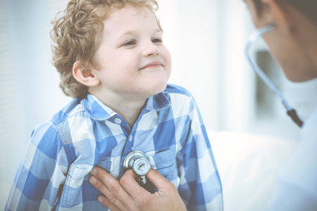 Doctor and patient child. Physician examining little boy. Regular medical visit in clinic. Medicine and health care conceptの写真素材