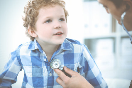 Doctor and patient child. Physician examining little boy. Regular medical visit in clinic. Medicine and health care conceptの写真素材