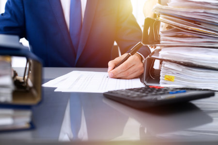 Bookkeeper or financial inspector and secretary making report, calculating or checking balance. Internal Revenue Service inspector checking financial document. Audit concept.の写真素材