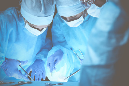 Group of surgeons at work while operating at hospital. Health care and veterinary conceptの写真素材