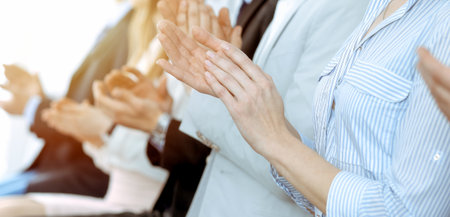 Business people clapping and applause at meeting or conference, close-up of hands. Group of unknown businessmen and women in modern white office. Success teamwork or corporate coaching conceptの写真素材