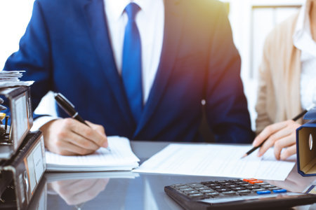 Bookkeeper or financial inspector and secretary making report, calculating or checking balance. Internal Revenue Service inspector checking financial document. Business, tax and audit conceptsの写真素材