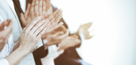 Business people clapping and applause at meeting or conference, close-up of hands. Group of unknown businessmen and women in modern white office. Success teamwork or corporate coaching conceptの写真素材