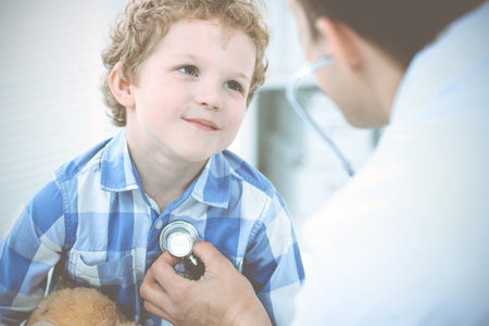 Doctor and patient child. Physician examining little boy. Regular medical visit in clinic. Medicine and health care conceptの写真素材