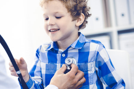 Doctor and patient child. Physician examining little boy. Regular medical visit in clinic. Medicine and health care conceptの写真素材