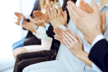 Business people clapping and applause at meeting or conference, close-up of hands. Group of unknown businessmen and women in modern white office. Success teamwork or corporate coaching conceptの写真素材