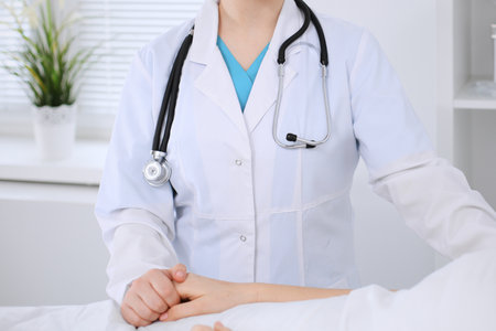 Female doctor holding application form while consulting patient.の写真素材
