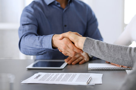 Group of business people shaking hands after discussing questions at meeting in modern office. Handshake close-up. Teamwork, partnership and agreement in business conceptの写真素材