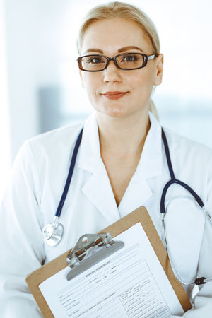 Doctor woman adult standing straight in hospital office, portrait. Perfect medical service in clinic. Medicine and healthcare conceptsの写真素材