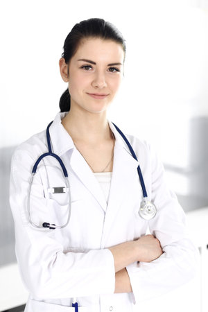 Doctor woman cheerful smiling at camera. Perfect medical service in clinic. Happy future in medicine and healthcareの写真素材