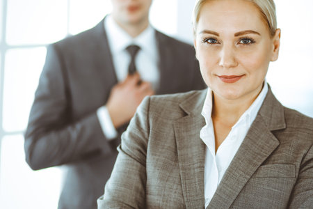 Business woman standing straight with colleague businessman in office, headshot. Success and corporate partnership conceptの写真素材