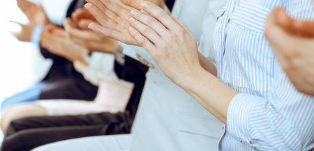 Business people clapping and applause at meeting or conference, close-up of hands. Group of unknown businessmen and women in modern white office. Success teamwork or corporate coaching conceptの写真素材