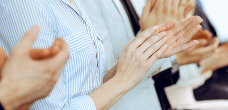 Business people clapping and applause at meeting or conference, close-up of hands. Group of unknown businessmen and women in modern white office. Success teamwork or corporate coaching conceptの写真素材