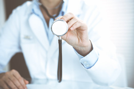 Doctor woman holds stethoscope head, close-up. Physician ready to examine and help patient. Helping and insurance in health care, best treatment and medicine concept.の写真素材