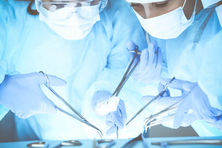 Close-up of medical team performing operation. Group of surgeons at work are busy of patient. Medicine, veterinary or healthcare and emergency in hospital.の写真素材