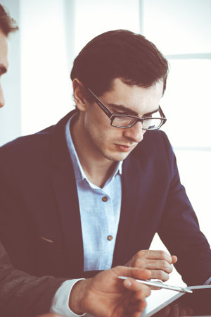 Businessmen working with computer in modern office. Headshot of male entrepreneur or company manager at workplace. Partners discussing contract. Business conceptの写真素材