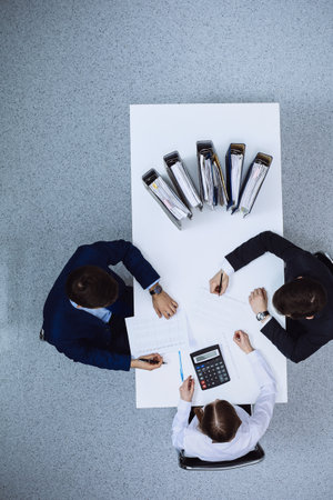 Business people at meeting, view from above. Bookkeeper or financial inspector making report, calculating or checking balanceの写真素材