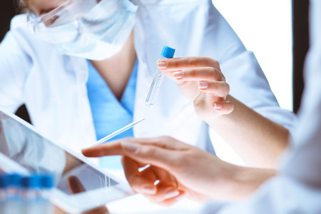 Coronavirus pandemic. Professional female scientist in protective eyeglasses researching tube with reagents in laboratory. Concepts of medicine and virus protectionの写真素材