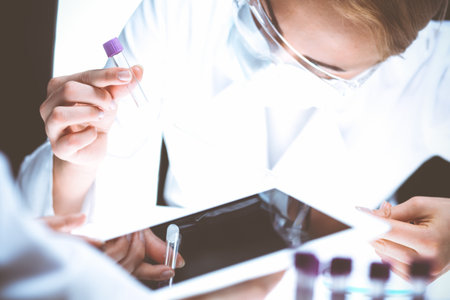 Coronavirus pandemic. Professional female scientist in protective eyeglasses researching tube with reagents in laboratory. Concepts of medicine and virus protectionの写真素材