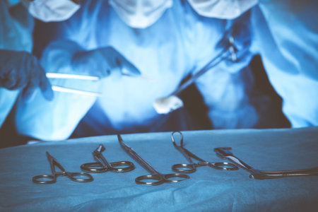 Group of surgeons wearing safety masks performing operation. Medicine concept.の写真素材