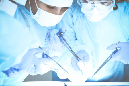 Close-up of medical team performing operation. Group of surgeons at work are busy of patient. Medicine, veterinary or healthcare and emergency in hospital.の写真素材