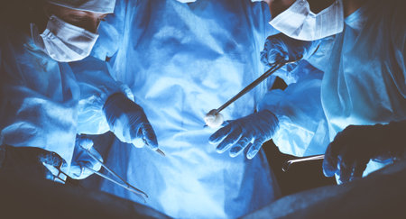 Group of surgeons wearing safety masks performing operation. Medicine conceptの写真素材