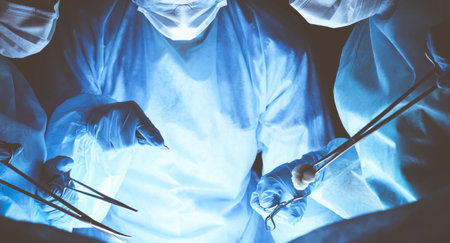 Group of surgeons wearing safety masks performing operation. Medicine concept