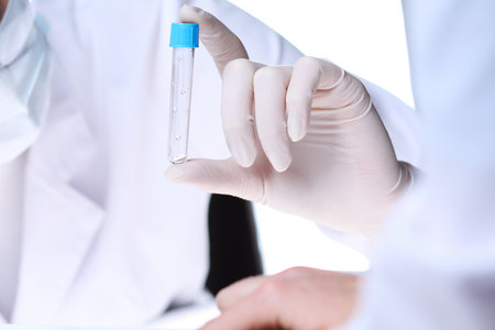 Coronavirus pandemic. Professional female scientist in protective eyeglasses researching tube with reagents in laboratory. Concepts of medicine and virus protectionの写真素材