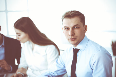 Group of business people discussing questions at meeting in modern office. Headshot of businessman at negotiation. Teamwork, partnership and business conceptの写真素材