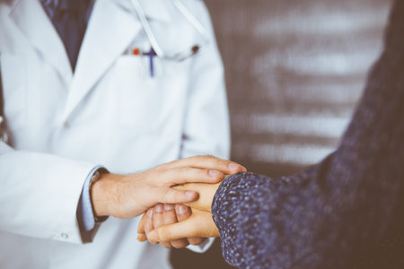 Friendly red-beard doctor reassuring his female patient, close-up. Medical ethics and trust concept, medicine themeの写真素材