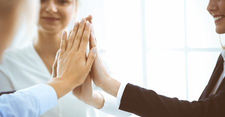 Business people happy showing teamwork and giving five showing unity and partnership. Success and...