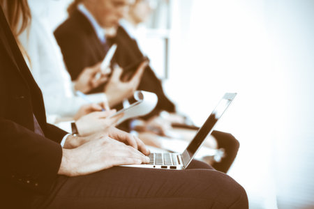 Business people working at meeting or conference, close-up of hands. Group of unknown businessmen and women in modern white office. Teamwork or coaching conceptの写真素材