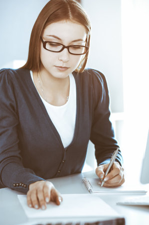 Accountant checking financial statement or counting by calculator income for tax form, hands close-up. Business woman sitting and working at the desk in office. Audit conceptの写真素材