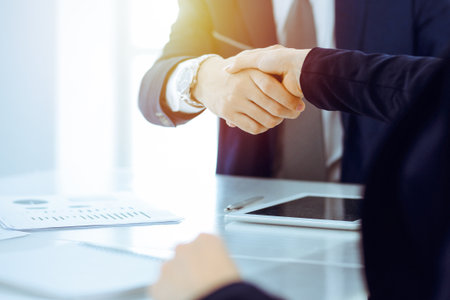 Businesspeople or lawyers shaking hands finishing up meeting or negotiation in sunny office. Business handshake and partnershipの写真素材
